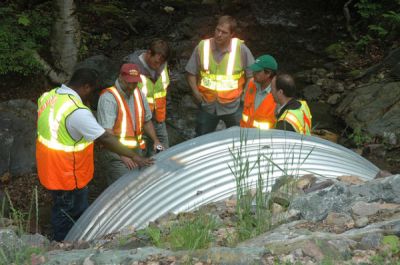 men in group being trained at site of large culvert