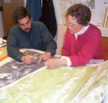 people working with watershed maps at a table